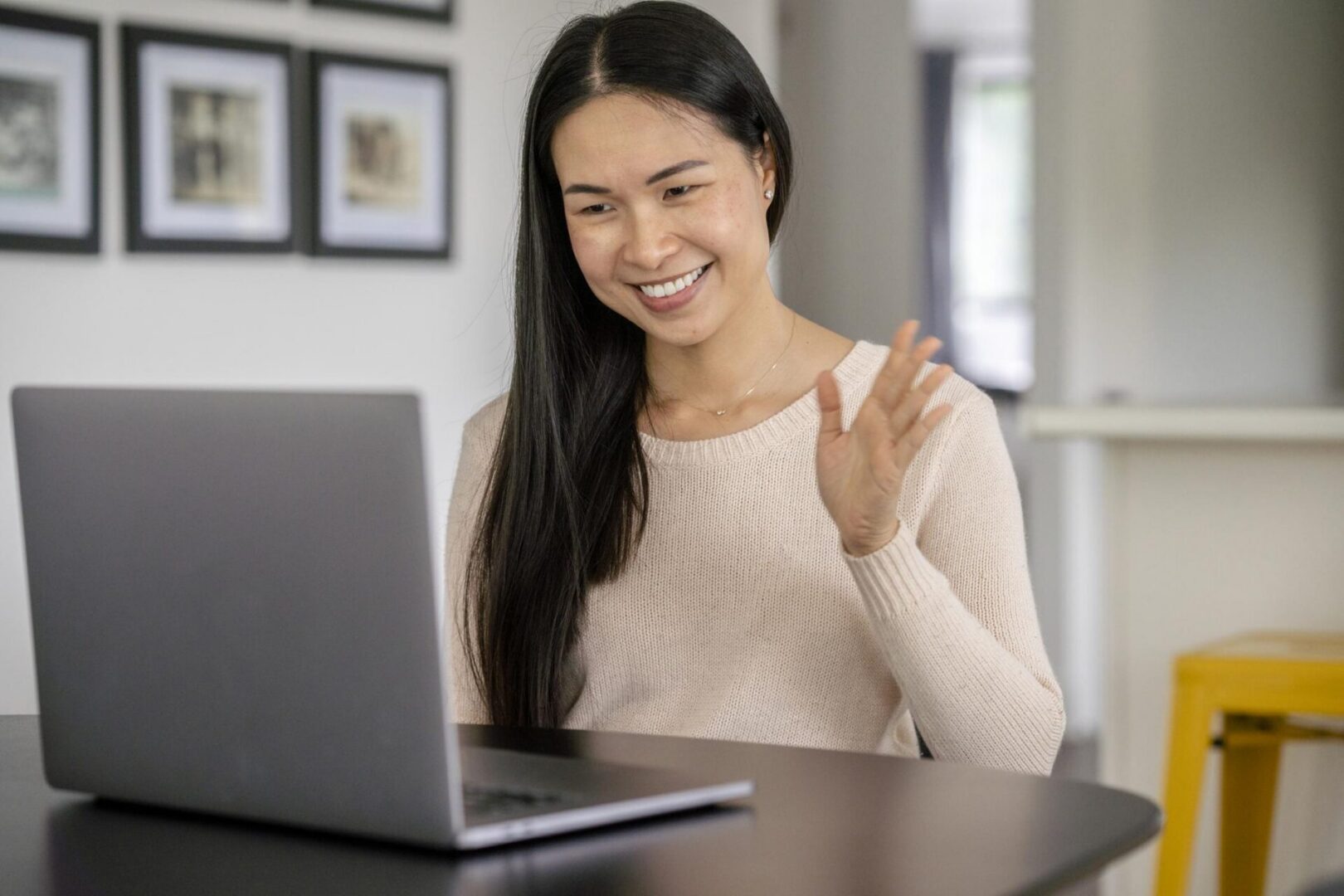 Woman waving during a video call.
